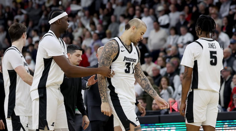Providence forward Duncan Powell (31) is escorted off the court after getting ejected following a fight during the second half of an NCAA college basketball game against St. John's, Saturday, Feb. 14, 2026, in Providence, R.I. (AP Photo/Mark Stockwell)