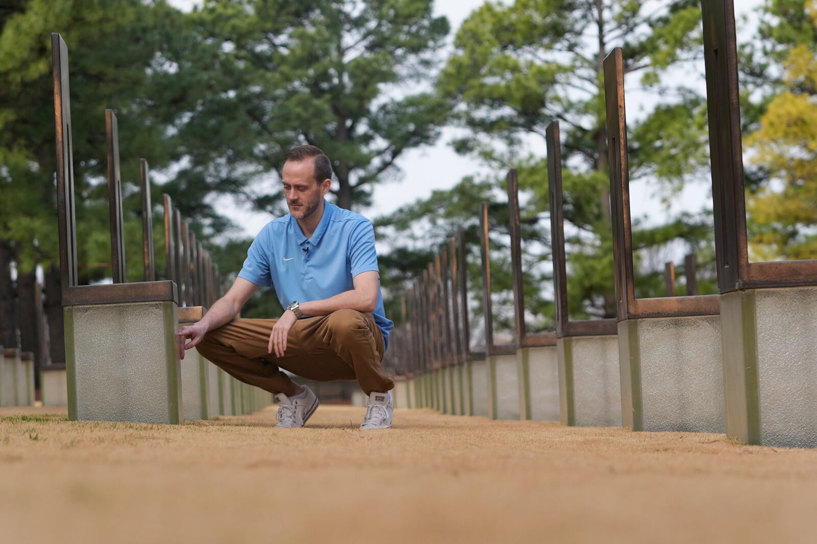 Austin Allen touches a memorial for his deceased father, Ted Allen, in the Field of Empty Chairs section of the Oklahoma City National Memorial & Museum on March 12, 2025. Austin was 4 years old when his father died in the bombing of the Alfred P. Murrah Federal Building. (AP Photo/LM Otero)