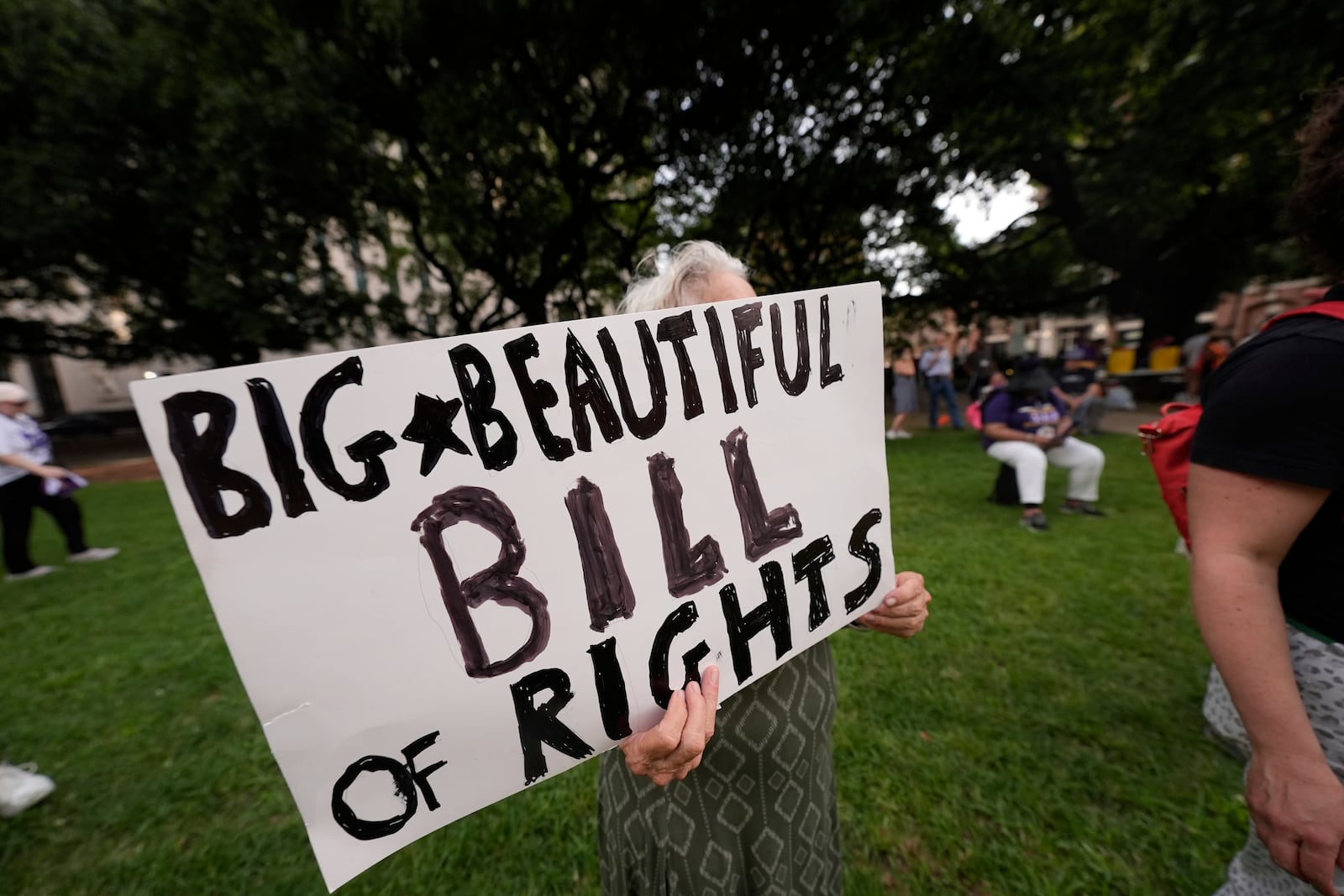 FILE - A protestor holds a sign during a demonstration in New Orleans, July 1, 2025. (AP Photo/Gerald Herbert, File)