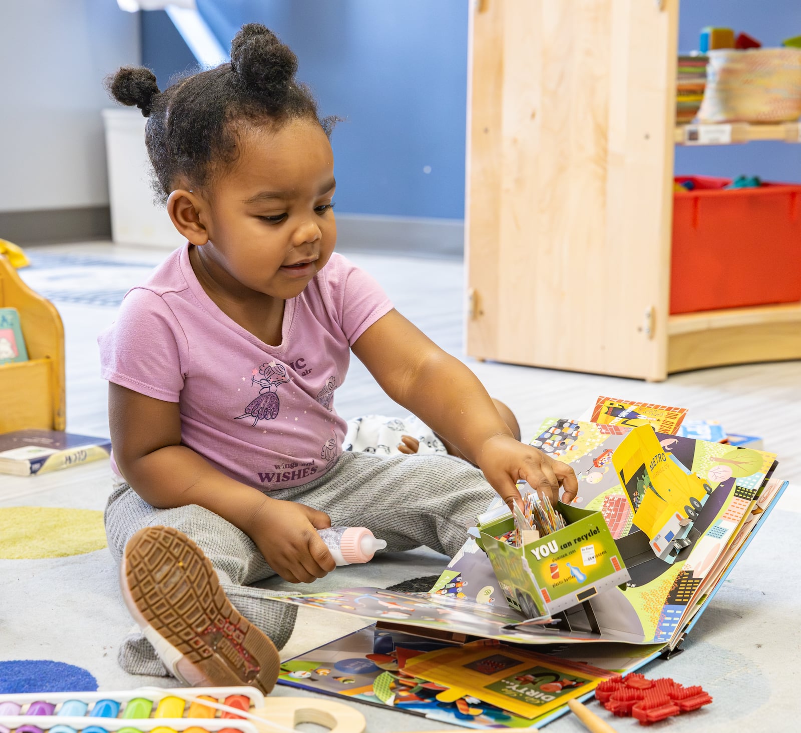 A child enrolled at Mini University's Sinclair Community College location plays with a book on Tuesday, March 10. BRYANT BILLING / STAFF