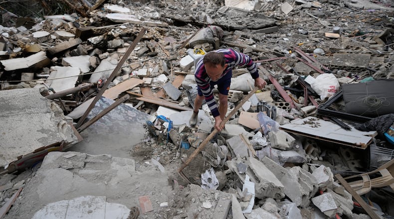 A man removes rubbles as he looks for missed stuff from his destroyed house that was hit in an Israeli airstrike in the southern port city of Tyre, Lebanon, Thursday, March 26, 2026. (AP Photo/Hussein Malla)