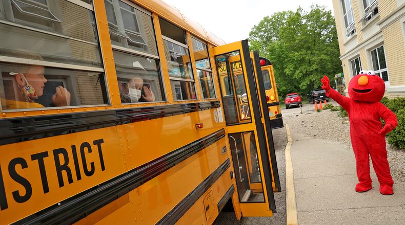 Preschool students at Rockway Elementary School wave to an ELMO character from the bus windows as they leave Rockway for the last time Tuesday. BILL LACKEY/STAFF