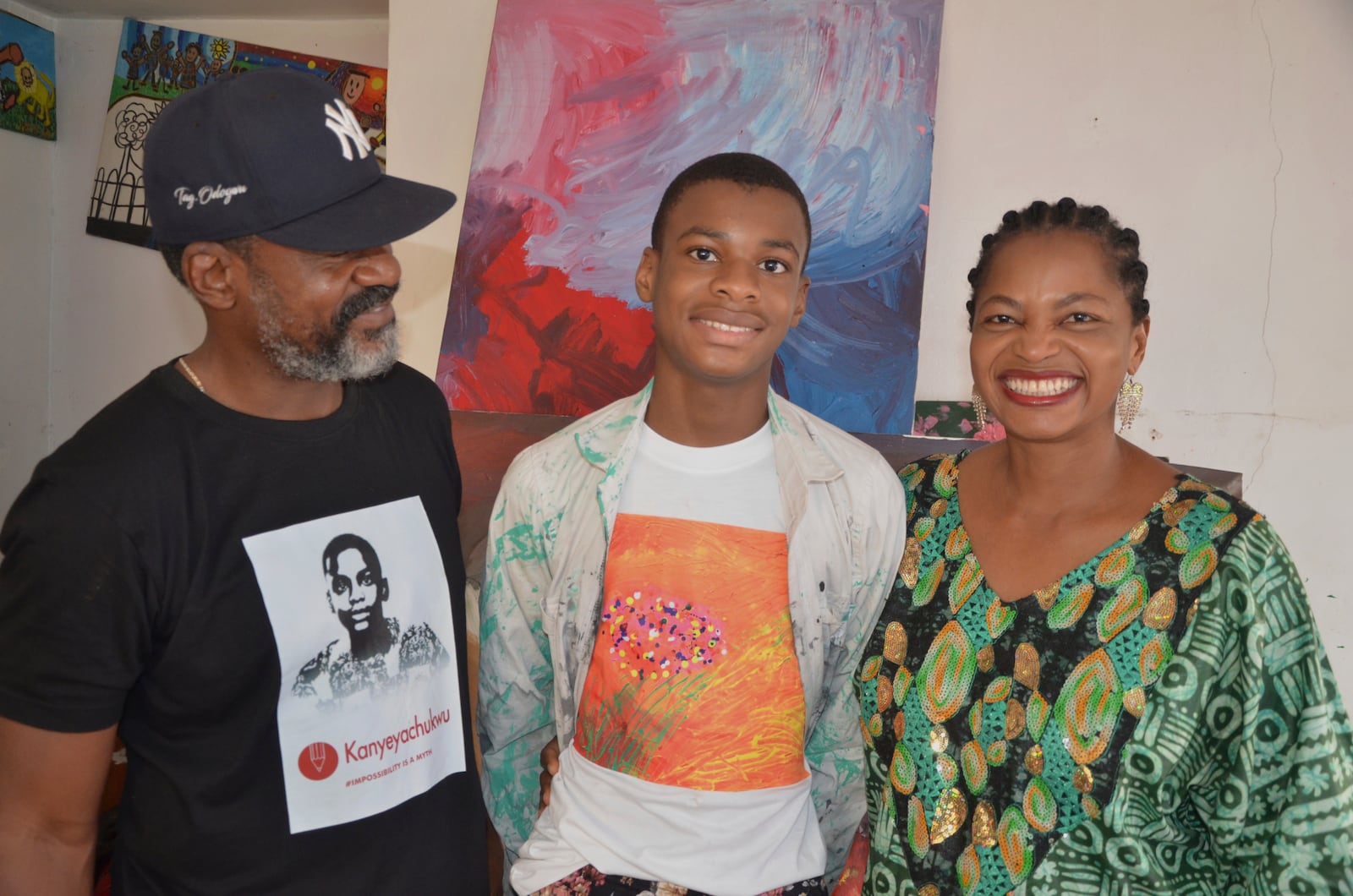 Kanyeyachukwu Tagbo Okeke, a 15 year-old autistic Nigerian, who set a Guinness World Record for the world's largest art canvas, is photograph with his parents in Abuja, Nigeria, Friday, April 18, 2025. (AP Photo/Olamikan Gbemiga)