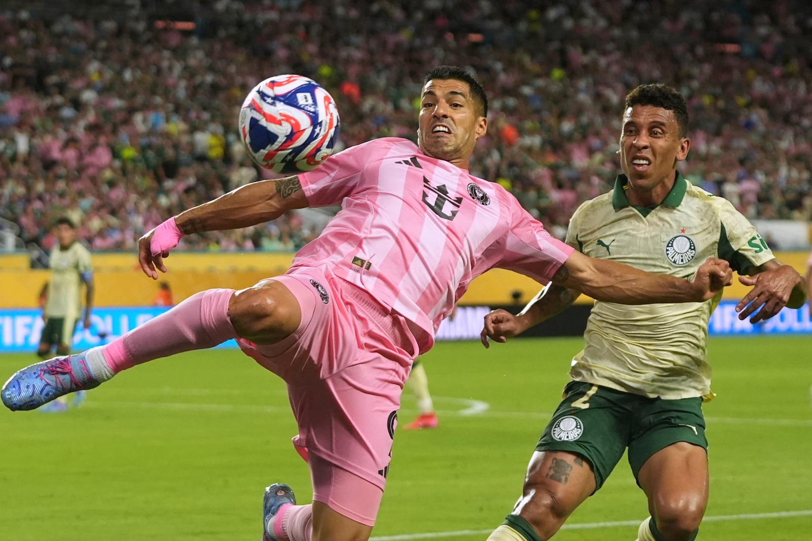 Inter Miami's Luis Suarez kicks the ball away from Palmeiras' Marcos Rocha during the Club World Cup Group A soccer match between Inter Miami and Palmeiras in Miami Gardens, Fla., Monday, June 23, 2025. (AP Photo/Lynne Sladky)