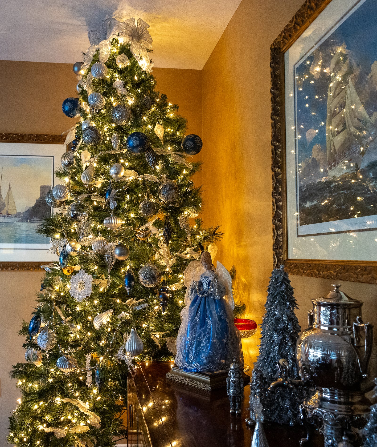 A 12-foot tree in the dining room of the Wales' home in Miami Twp. shimmers with silver, blue and white lights. BRYANT BILLING/STAFF