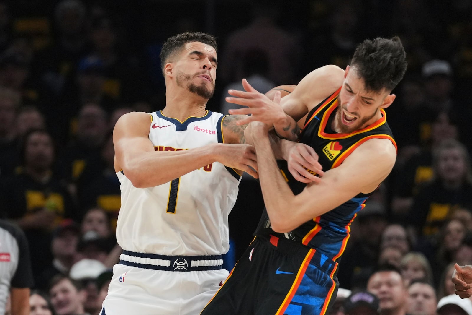 Denver Nuggets forward Michael Porter Jr. (1) and Oklahoma City Thunder forward Chet Holmgren, right, compete for control of the ball in the first half of Game 2 in the conference semifinals of the NBA basketball playoffs, Wednesday, May 7, 2025, in Oklahoma City. (AP Photo/Kyle Phillips)