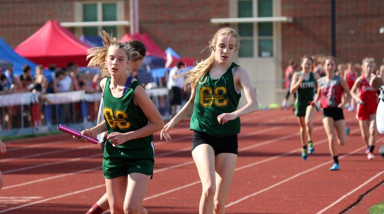 Catholic Central sophomore Lauren Stannard (left) receives the baton from sophomore teammate Bridget Engel to start the second leg of the 3,200 relay at the Division III district track and field meet in West Milton on Tuesday. The Irish team of Engel, Stannard, junior Sydney Yontz and sophomore Addie Engel won the district title to advance to next week’s regional meet. Greg Billing / Contributed