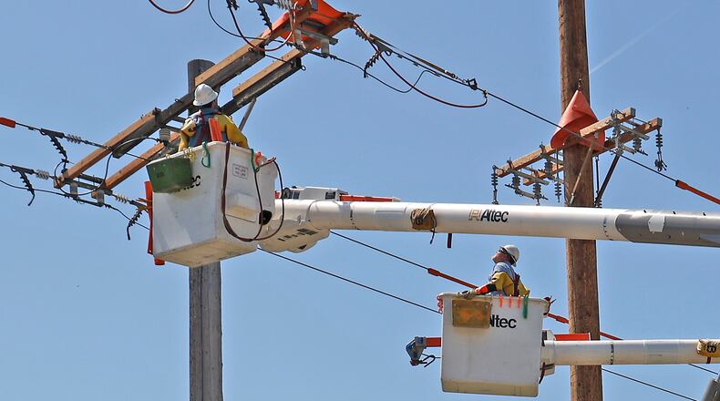 An Ohio Edison crew works on the power lines at the intersection of Urbana Road and Moorefield Road Wednesday, April 19, 2023. BILL LACKEY/STAFF