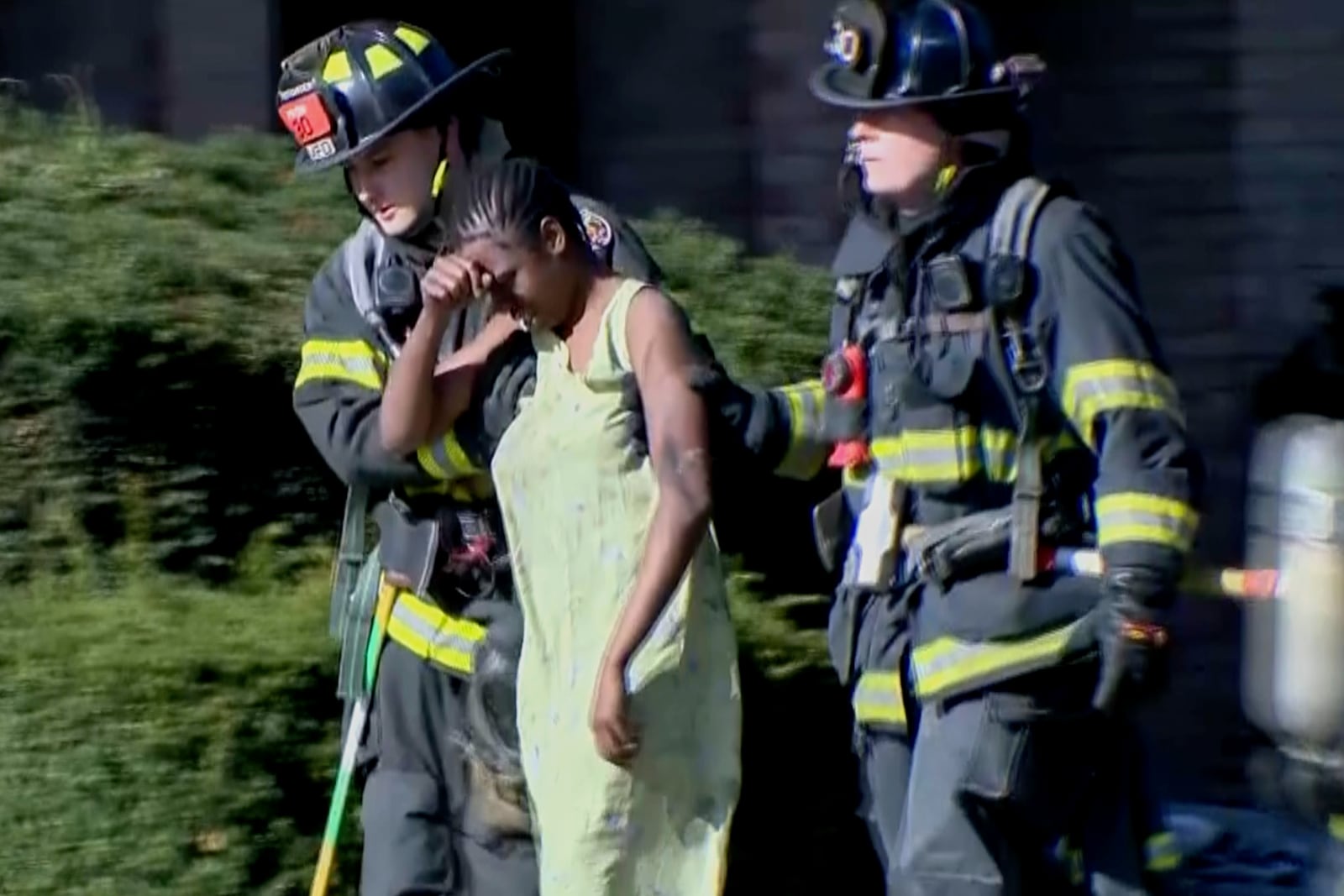 This image taken from video provided by WISN show a resident being escorted by firefighters at the site of an apartment building fire in Milwaukee, Wis., Sunday, May 11, 2025. (WISN via AP)