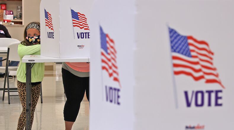 Katlee Chapman, 7, looks around the room as she wait for her mother to vote Tuesday at the Lawrenceville Church of God. BILL LACKEY/STAFF