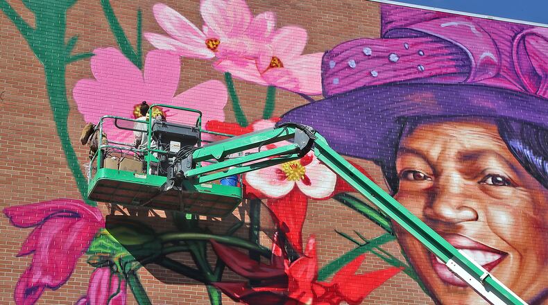 The muralist, Gaia, works on the mural of civil rights advocate Hattie Moseley in this October 2022 file photo. BILL LACKEY/STAFF