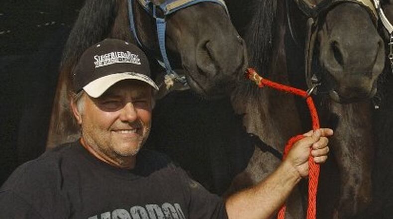 In an August 2008 photo, Terry Thompson stands with some of his award-winning Percheron horses on his farm west of Zanesville, Ohio. Authorities said Thompson, a game-preserve owner, apparently freed dozens of wild animals, including tigers and grizzly bears, and then killed himself on Oct. 18, 2011. (AP Photo/Zanesville Times Recorder, Chris Crook)