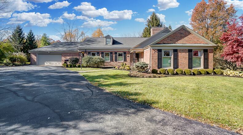The 3-bedroom brick ranch on a wooded lot offers about 3,580 sq. ft. of living space. A driveway leads to the 2-car garage, a concrete walk and covered patio. CONTRIBUTED PHOTO