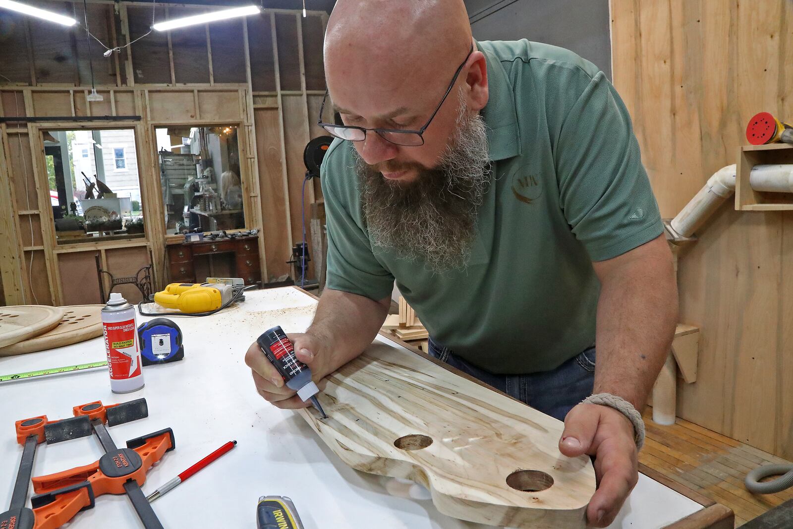 Andy Mitterholzer, owner of Middle of the Wood, works on a cutting board in his workshop located behind his store front in Urbana Wednesday, Oct. 26, 2022. BILL LACKEY/STAFF