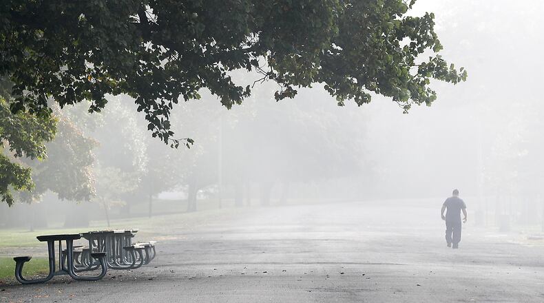 A man is shrouded in the fog that blanketed the area Oct. 5 as he walks at Snyder Park in Springfield. BILL LACKEY/STAFF