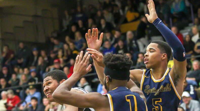 Centerville High School’s Mo Njie is guarded by Springfield’s Larry Stephens and Raheim Moss during their game at Centerville High School on Friday, Dec. 14. The Wildcats won 64-60. CONTRIBUTED PHOTO BY MICHAEL COOPER