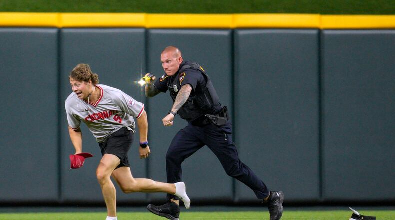 A spectator who got onto the field is chased during the ninth inning of a baseball game between the Cleveland Guardians and the Cincinnati Reds in Cincinnati, Tuesday, June 11, 2024. (AP Photo/Jeff Dean)