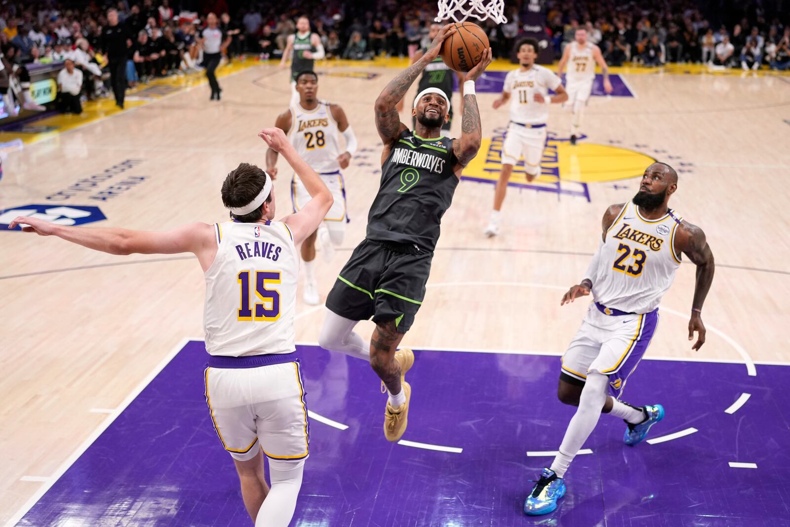 Minnesota Timberwolves guard Nickeil Alexander-Walker (9) shoots as Los Angeles Lakers guard Austin Reaves (15) and forward LeBron James (23) defend during the first half in Game 1 of an NBA first-round playoff series Saturday, April 19, 2025, in Los Angeles. (AP Photo/Mark J. Terrill)
