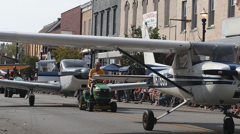 The New Carlisle Heritage of Flight Festival started Saturday with the Airplane Parade down Main Street. Hundreds of people lined the street to see the floats as well as the airplanes towed by vintage tractors. BILL LACKEY/STAFF