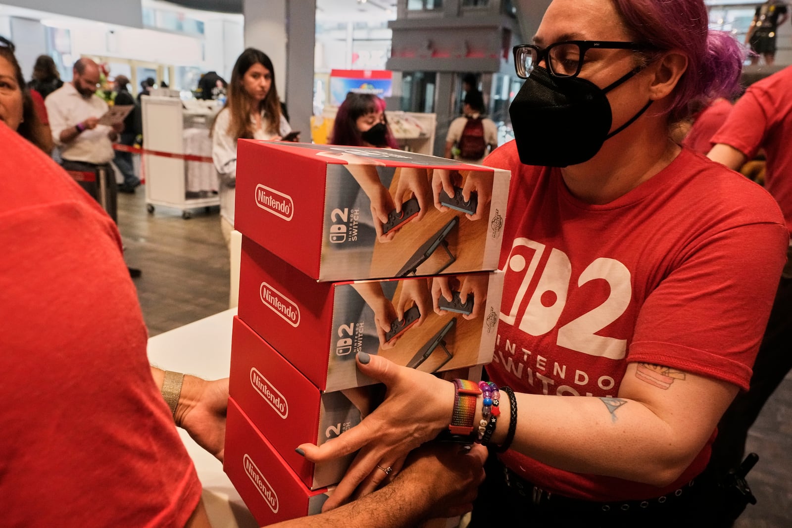 A stack of the Nintendo Switch 2 devices are handed off at the Nintendo store in New York's Rockefeller Center, Thursday, June 5, 2025. (AP Photo/Richard Drew)
