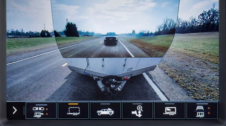 This image provided by General Motors, shows the display of a 2020 GMC Sierra HD feature called Transparent Trailer, one of the few pickup trucks that provides an image of the road behind a trailer. This optional feature uses augmented reality to project an image of the road on the front of a trailer, giving the illusion of a transparent trailer. (General Motors via AP)