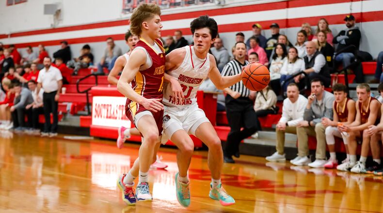 Southeastern High School senior Cole Walton drives past Northeastern junior Noah Federinko during their game on Tuesday night in South Charleston. Walton had a game-high 23 points as the Trojans won 62-41. Michael Cooper/CONTRIBUTED