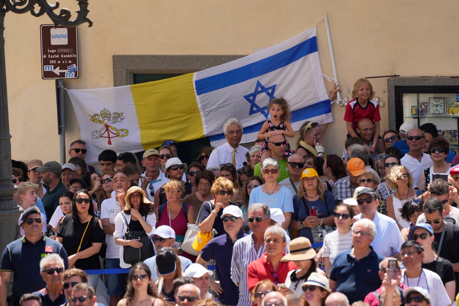 Faithful hold Israel and Vatican flags during the noon Angelus prayer with Pope Leon XIV, in the square in front of the Apostolic Palace for in Castel Gandolfo, Italy, Sunday, July 20, 2025. (AP Photo/Gregorio Borgia)