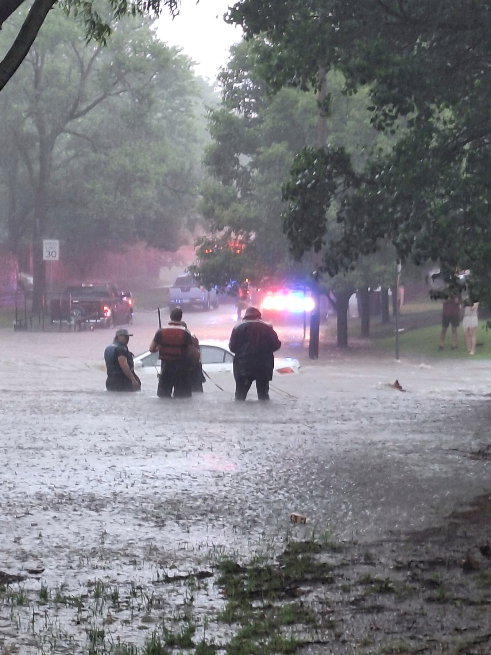 This photo provided by Colin Fee, a vehicle is surrounded by flood waters as heavy rains caused flash flooding in the Wichita area of south-central Kansas forcing firefighters to rescue dozens of people, including stranded motorists on Tuesday, June 3, 2025. (Colin Fee via AP)
