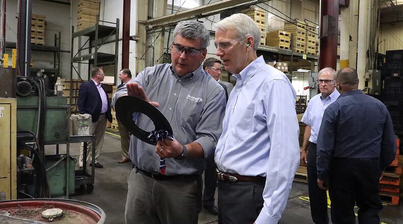 Andrew Brougher, from Morgal Machine Tool Company, shows Senator Rob Portman one of the parts the company produces Tuesday during a tour of the manufacturing plant. Senator Portman was participating in a workforce roundtable discussion hosted by the Chamber of Greater Springfield. BILL LACKEY/STAFF