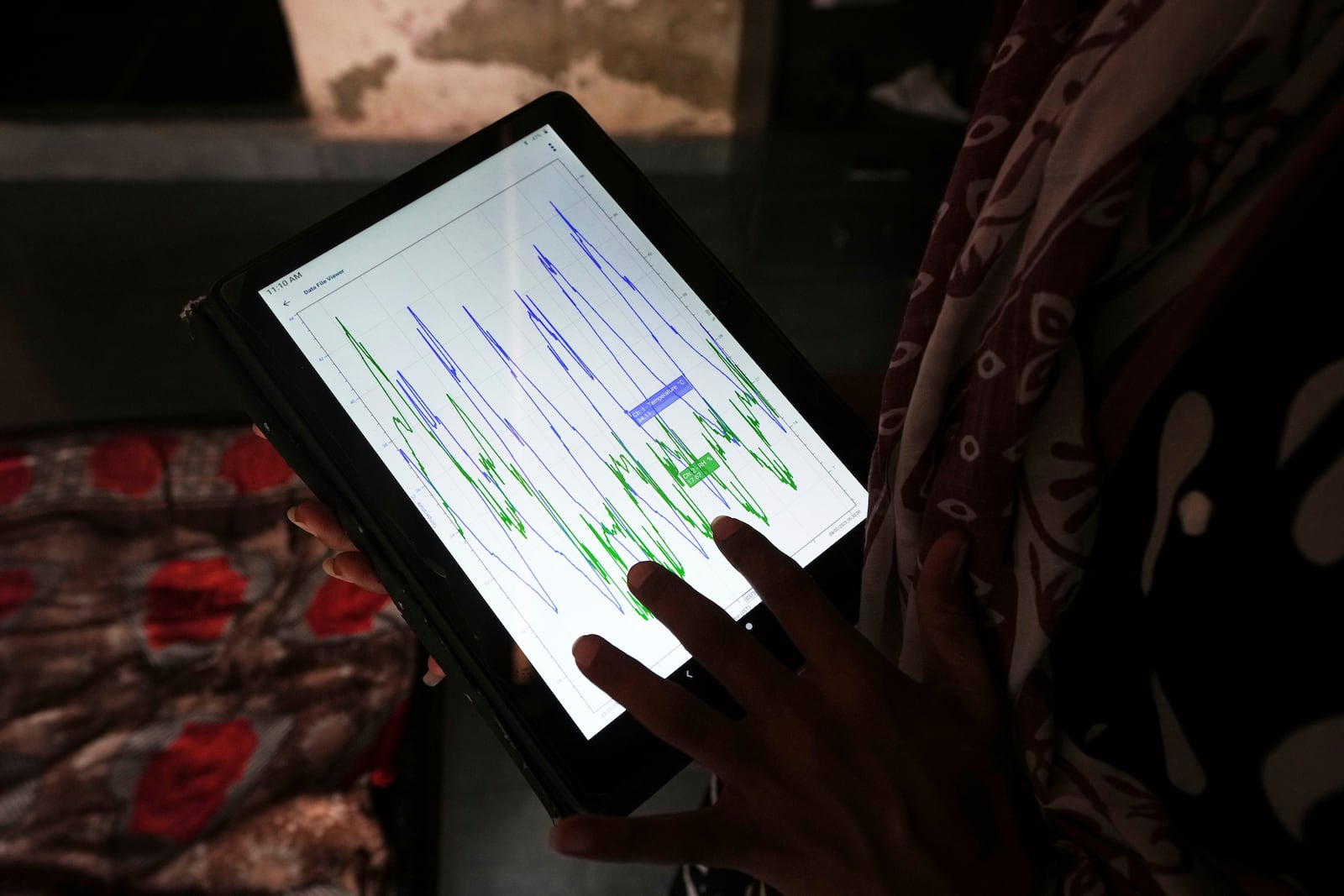 Field data collector Manisha Parmar gathers information from a logging device tied to the roof inside a house in Ahmedabad, India, Wednesday, April 2, 2025. (AP Photo/Ajit Solanki)