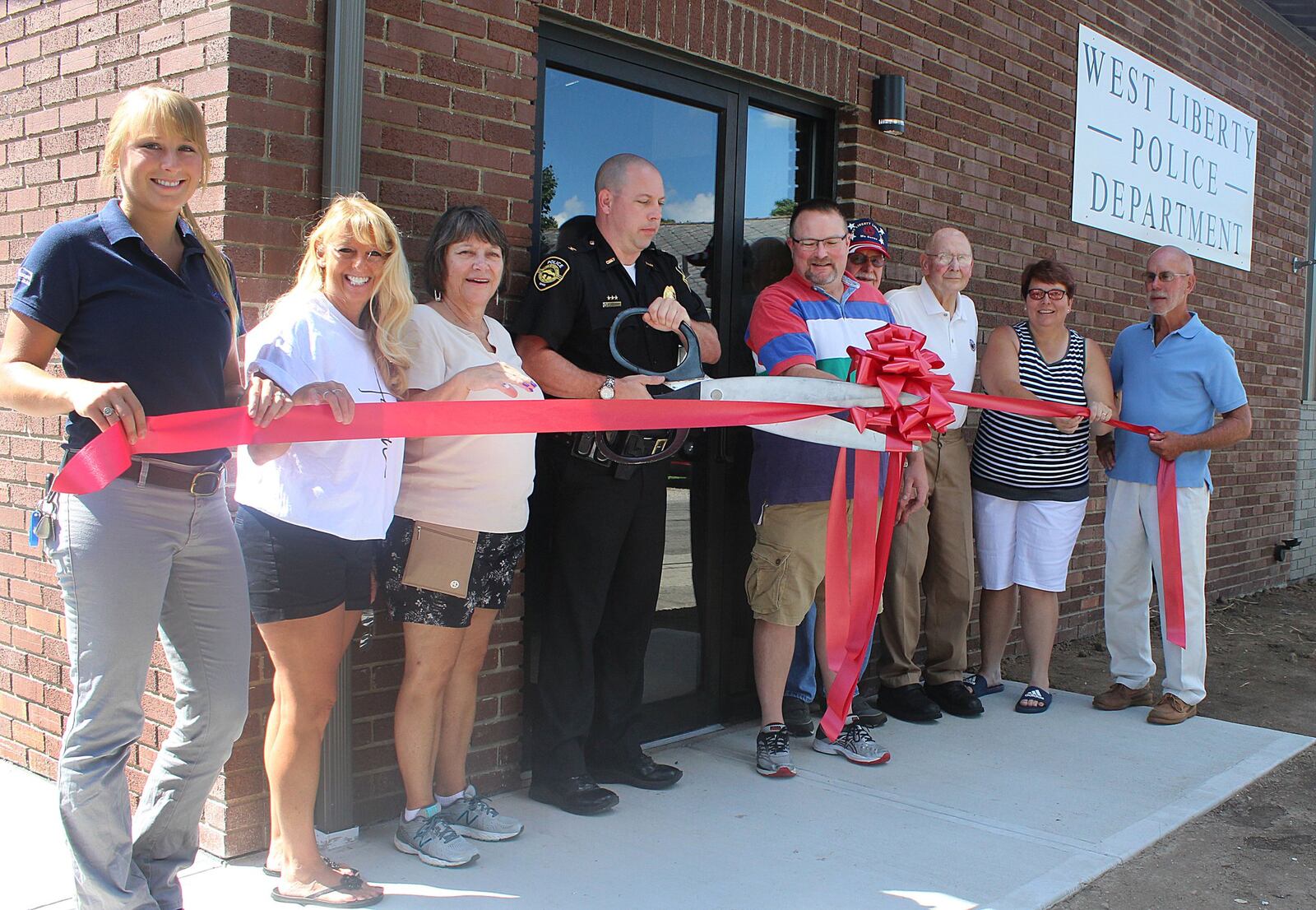West Liberty Police Chief Shane Oelker cuts the ribbon to open the new police station Monday afternoon. 