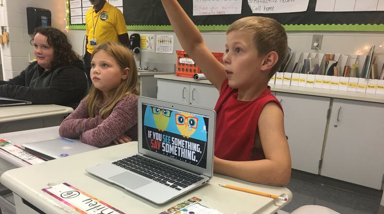 Riley Allen, a third grader at Kenwood Elementary School, raises his hand to answer a question during a “Say Something See Something” presentation last week.