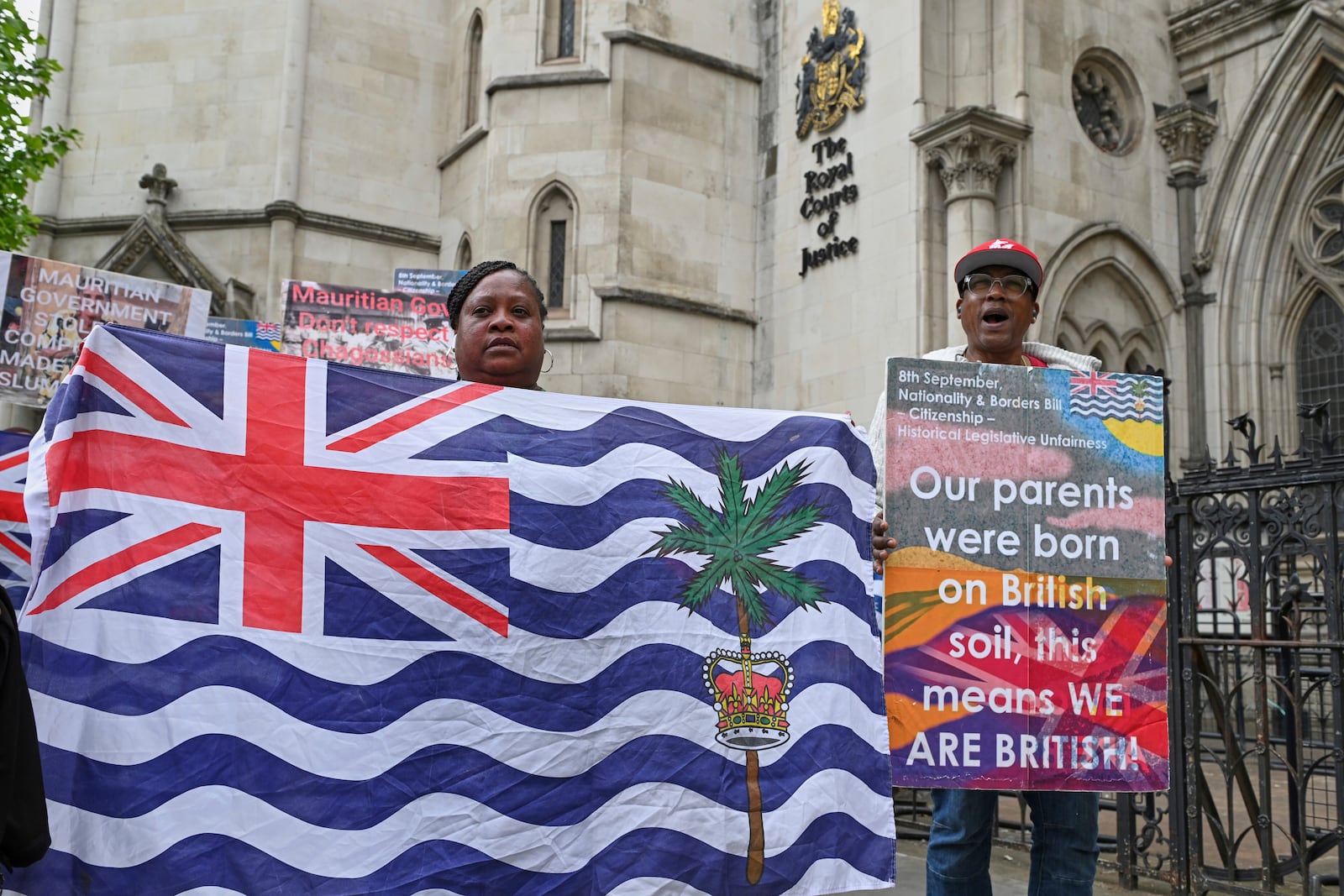 People demonstrate outside the High Court in London, Thursday, May 22, 2025, after a British court blocked the U.K. from transferring sovereignty over the Chagos Islands to Mauritius hours before the agreement was due to be signed. (AP Photo/Thomas Krych)