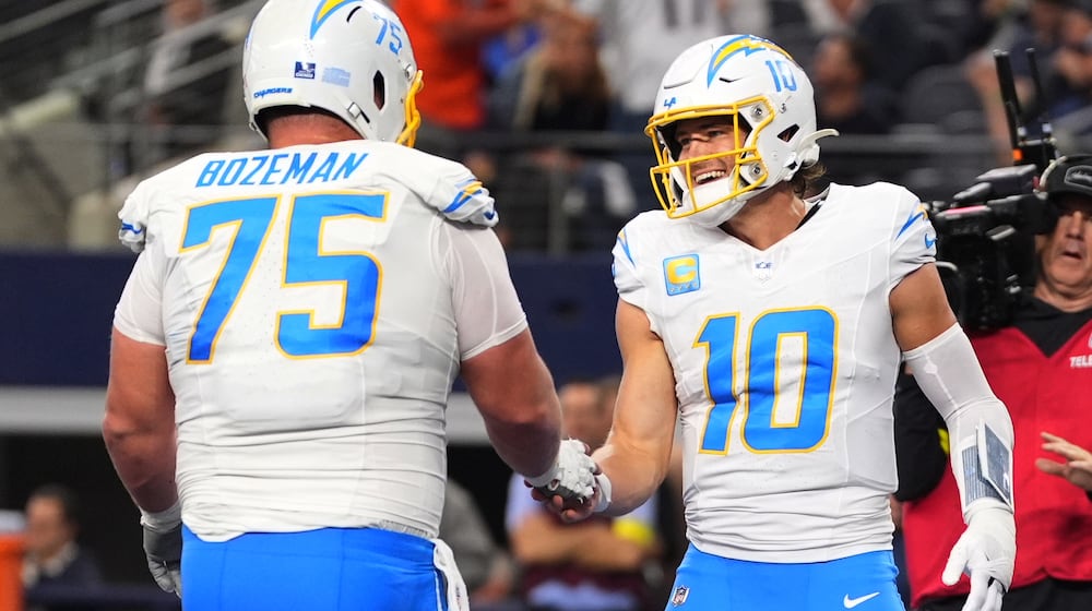 Los Angeles Chargers quarterback Justin Herbert (10) celebrates his touchdown with center Bradley Bozeman (75) during the first half of an NFL football game against the Dallas Cowboys, Sunday, Dec. 21, 2025, in Arlington, Texas. (AP Photo/Tony Gutierrez)