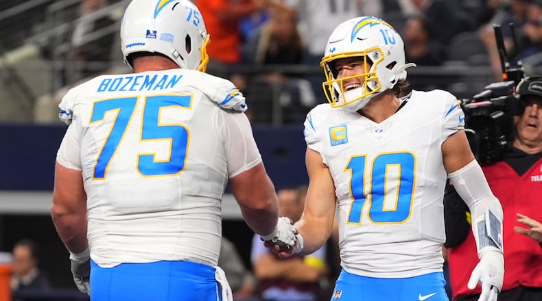 Los Angeles Chargers quarterback Justin Herbert (10) celebrates his touchdown with center Bradley Bozeman (75) during the first half of an NFL football game against the Dallas Cowboys, Sunday, Dec. 21, 2025, in Arlington, Texas. (AP Photo/Tony Gutierrez)