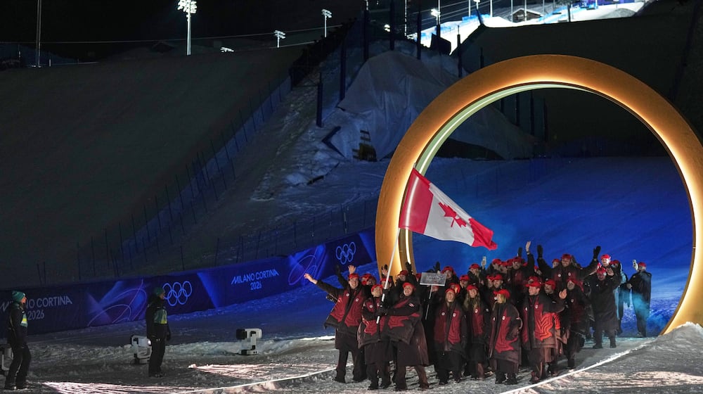 Marielle Thompson and Mikael Kingsbury, flag bearers of Canada walk with athletes during the Olympic opening ceremony at the 2026 Winter Olympics, in Livigno, Italy, Friday, Feb. 6, 2026. (AP Photo/Abbie Parr)