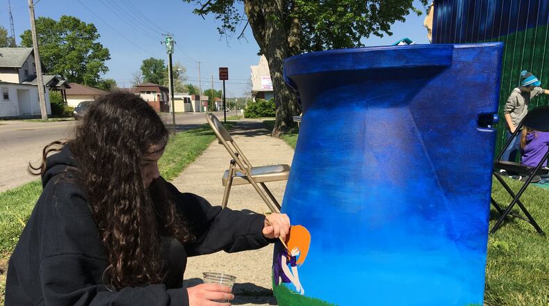 Jennah Kuhn, a Northridge Middle School student, paints a rain barrel that will be raffled at the unveiling of Project Jericho s Catching Light mural unveiling at the Clark County Solid Waste District Building on W. Main St. Contributed photo