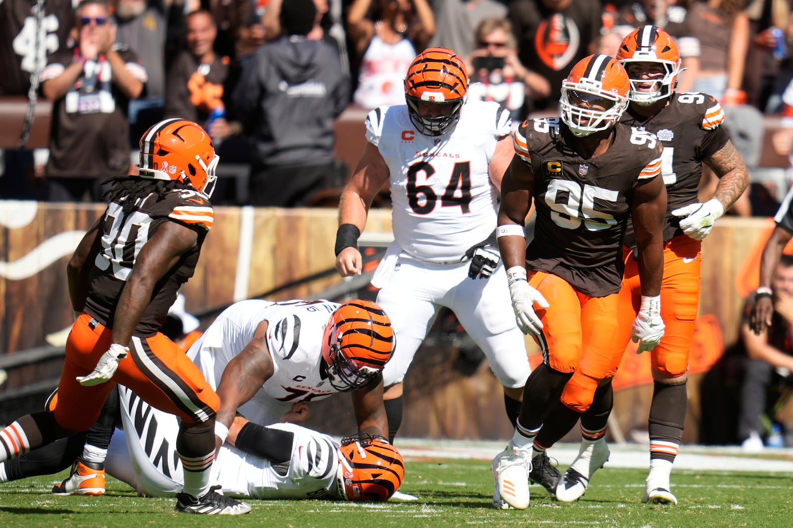 Cleveland Browns defensive end Myles Garrett (95) celebrates with linebacker Devin Bush (30) after sacking Cincinnati Bengals quarterback Joe Burrow during the second half of an NFL football game Sunday, Sept. 7, 2025, in Cleveland. (AP Photo/Sue Ogrocki)