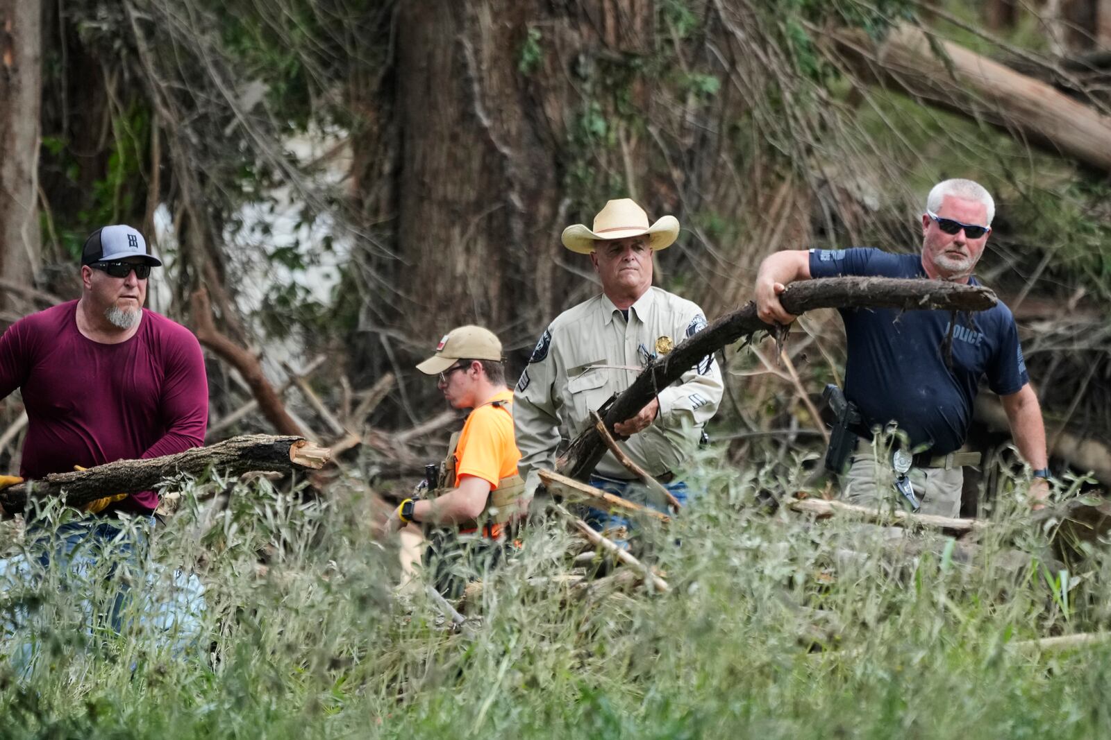 Law enforcement assist during clean-up efforts in Center Point, Texas, Monday, July 7, 2025. (AP Photo/Ashley Landis)