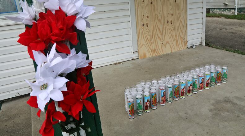 A memorial, made up of flowers and candles, has been made on the front porch at 41 North Douglas Avenue where the body of Gloria Dickinson was discovered Wednesday. BILL LACKEY/STAFF