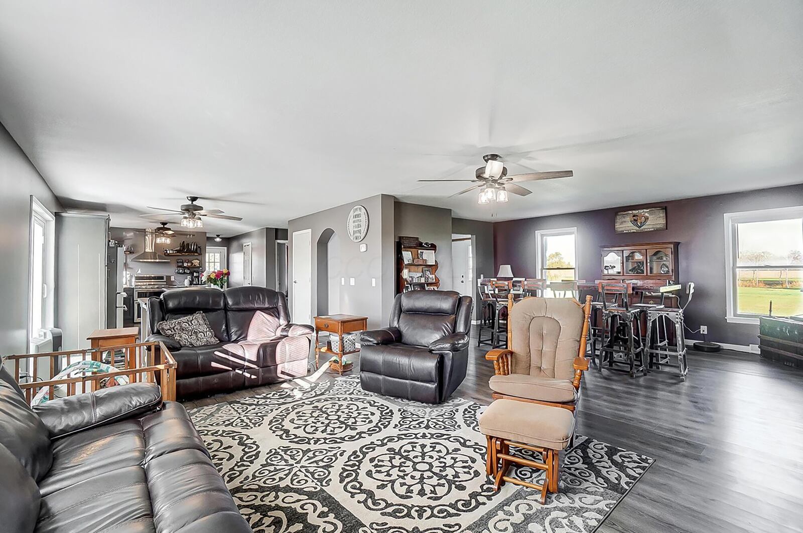 The living room has luxury vinyl tile flooring and is open to the both the kitchen and dining room.