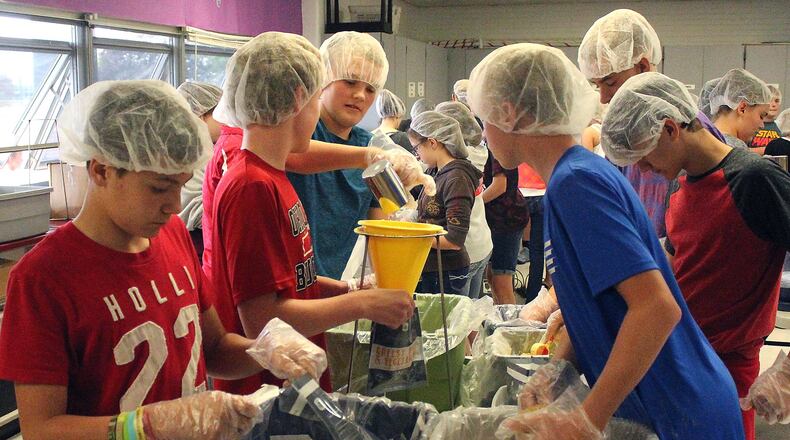 South Vienna Middle School eight grade students help package meals for the Second Harvest Food Bank. JEFF GUERINI/STAFF