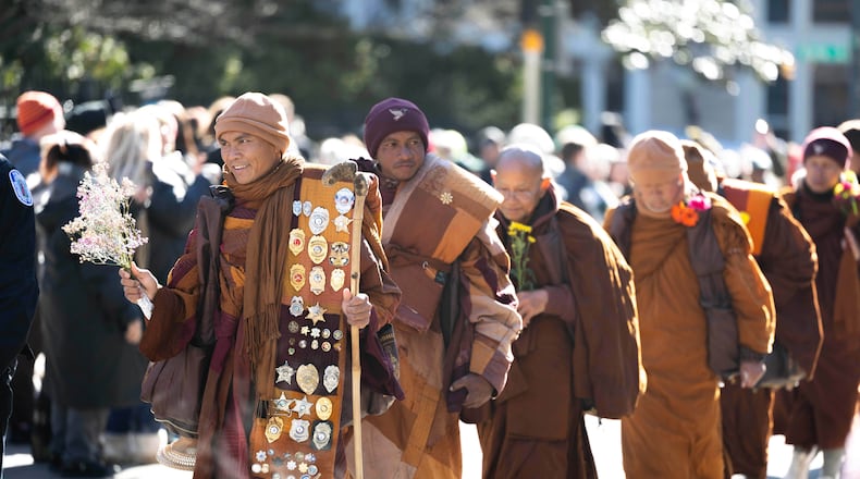 One of the Venerable Buddhist monks holds flowers as they walk for peace into downtown Richmond, Va., Monday, Feb. 2, 2026. (Mike Kropf/Richmond Times-Dispatch via AP)