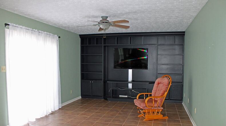 The focal point of the family room is a floor-to-ceiling shelving and entertainment center along the far wall.