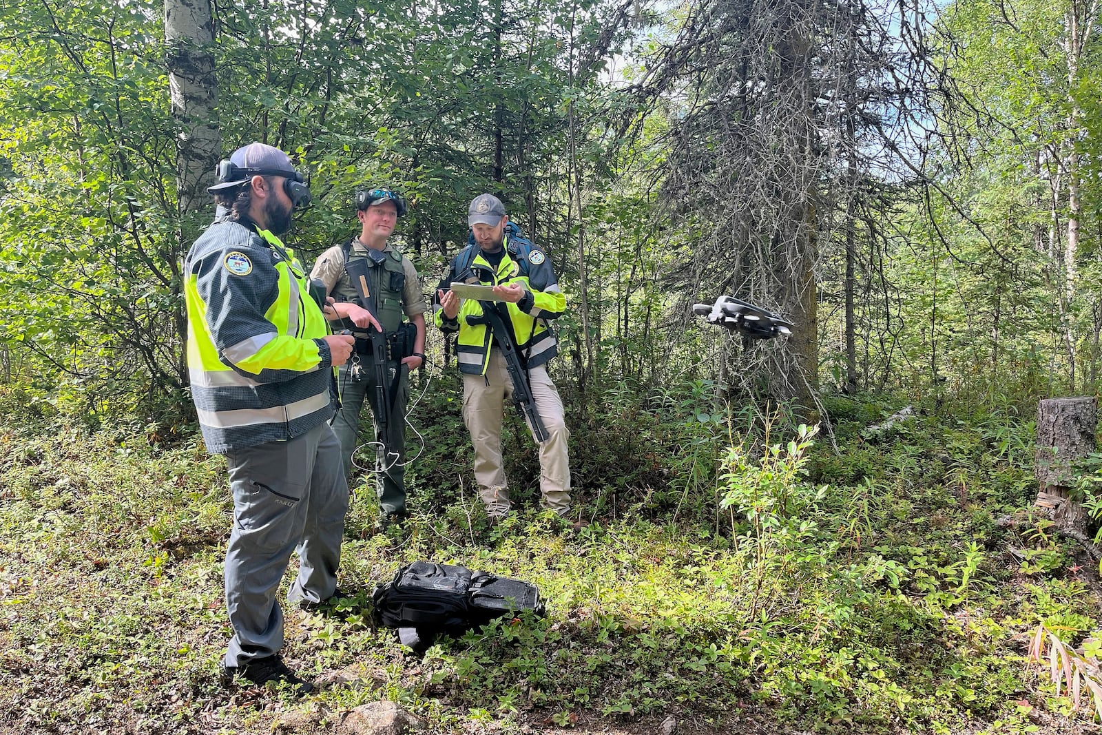 Wildlife officials prepare to fly a drone to look for a brown bear that had mauled a man on Saturday, July 26, 2025, near Eagle River, Alaska. (Timothy Burnett, Chugach State Park via AP)