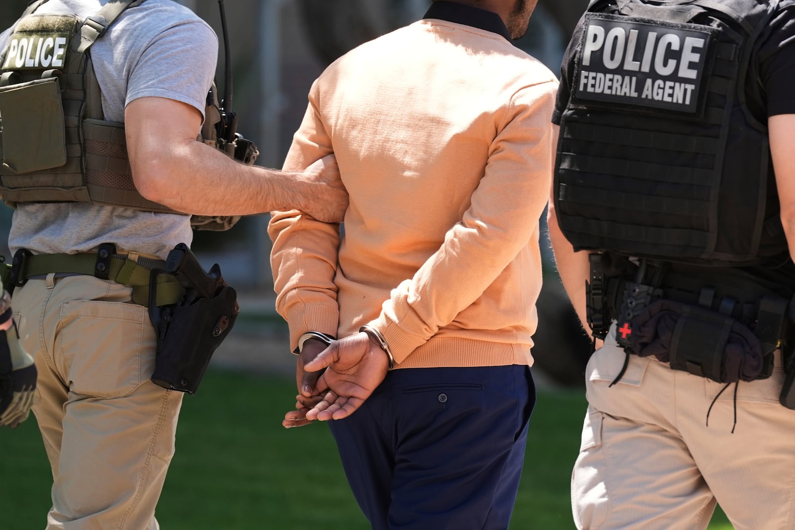 FILE - Federal agents take someone into custody after an immigration court hearing outside immigration court, May 21, 2025, in Phoenix. (AP Photo/Ross D. Franklin, File)