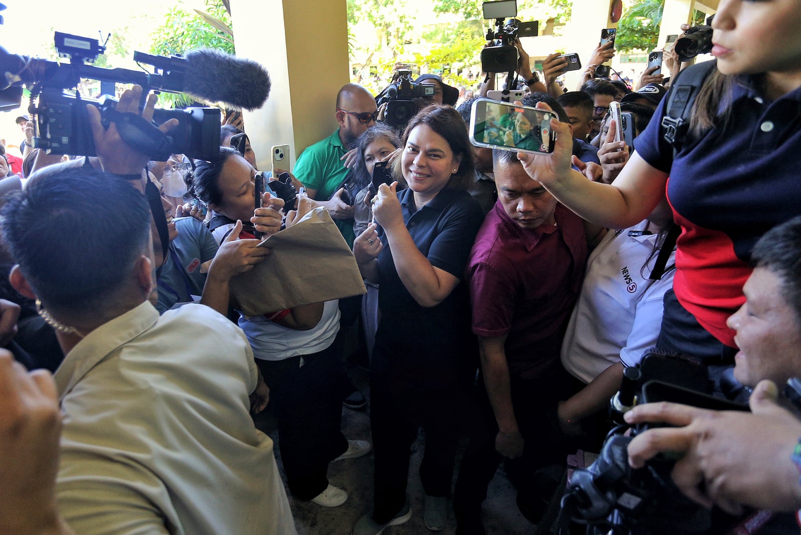 Philippine Vice President Sara Duterte, center, arrives to cast her vote at a polling center in Davao City, southern Philippines, Monday, May 12, 2025. (AP Photo/Manman Dejeto)