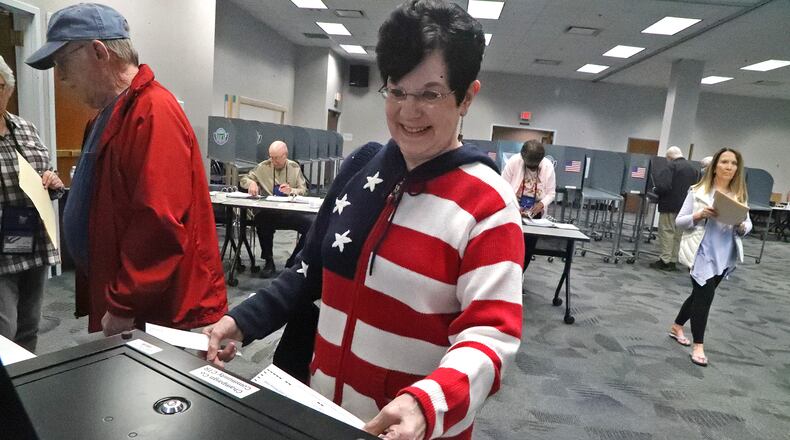 Marilyn Milbrandt was wearing her patriotic sweater as she puts her ballot in the voting machine during the May primary at the Champaign County Board of Elections. BILL LACKEY/STAFF