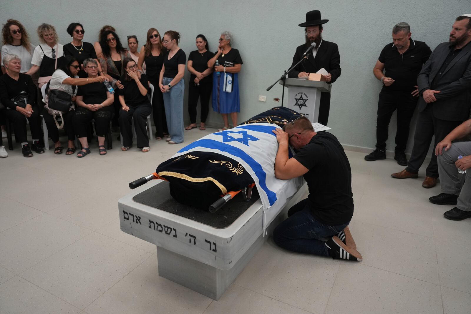 Nikolay Boguslavsky mourns over the body of his daughter, Noa Boguslavsky, 18, who was killed in an Iranian missile strike on a residential building yesterday, a day after the announcement of a ceasefire between Israel and Iran, during her funeral at the cemetery in Arad, Israel, Wednesday, June 25, 2025. (AP Photo/Ariel Schalit)