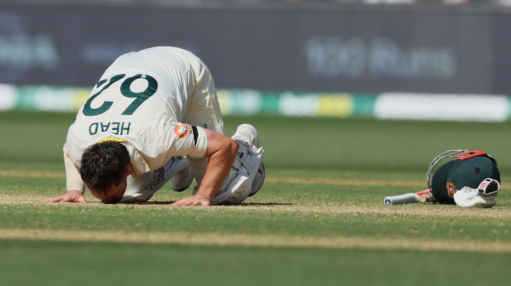 Australia's Travis Head kisses the pitch after scoring a century during play on day three of the third Ashes cricket test between England and Australia in Adelaide, Australia, Friday, Dec. 19, 2025. (AP Photo/James Elsby)
